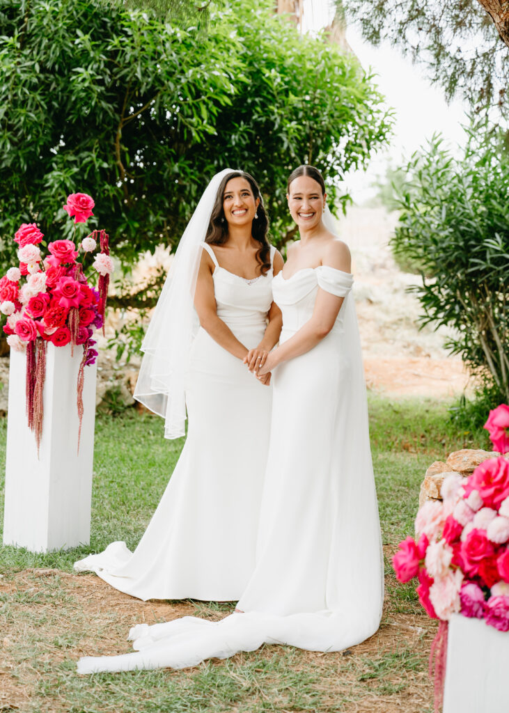 LGBTQ+ Zeremonie mit einer floralen Hochzeitsdekoration in pink.