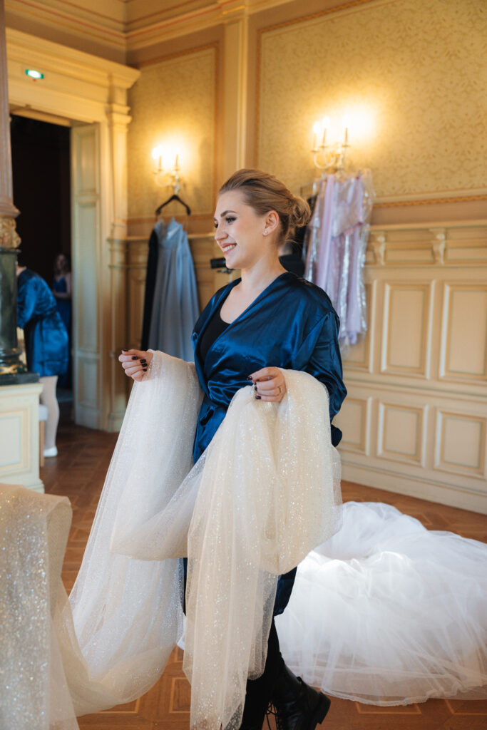 Eine Bridesmaid die den Schleier der Braut hält